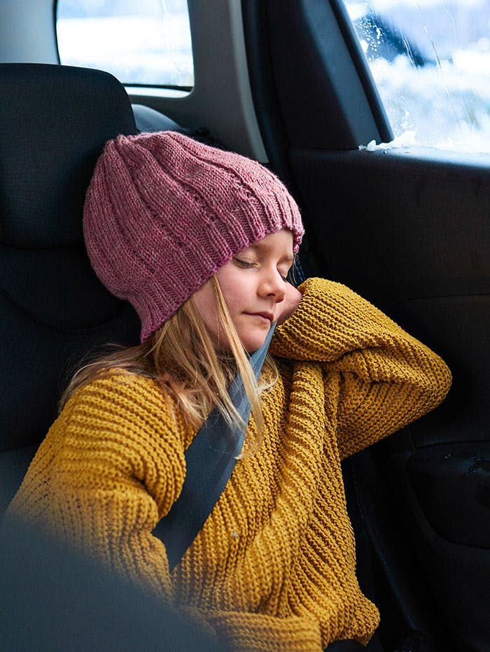 Young girl asleep in the back seat of a automobile